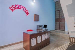 una oficina con recepción con un cartel feliz en la pared en SPOT ON Tomer Crown Palace, 