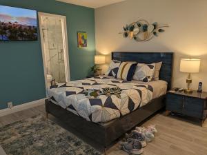 1 dormitorio con 1 cama y 1 mesa con lámparas en Cozy Fun-Size Getaway + Pool&Spa 5 mins to Beach en Fort Lauderdale