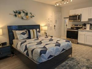 1 dormitorio con 1 cama y cocina en Cozy Fun-Size Getaway + Pool&Spa 5 mins to Beach en Fort Lauderdale