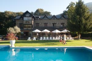 a hotel with a swimming pool in front of a building at Hotel Florido in Sort