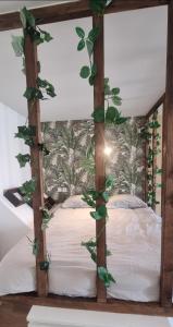 - une chambre dotée d'un lit avec des feuilles vertes dans l'établissement New jungle studio cœur de ville, à Pont-à-Mousson