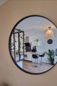a mirror reflecting a kitchen and a living room at New jungle studio cœur de ville in Pont-à-Mousson