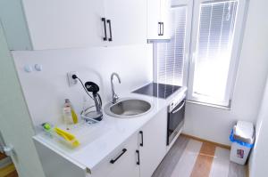 a small white kitchen with a sink and a sink at Central Vista Apartments Sarajevo in Sarajevo