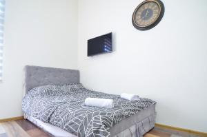 sypialnia z łóżkiem z zegarem na ścianie w obiekcie Central Vista Apartments Sarajevo w Sarajewie