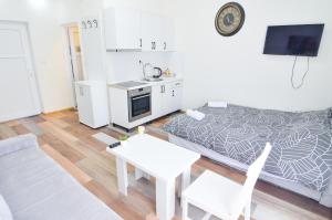a small room with a bed and a table and chairs at Central Vista Apartments Sarajevo in Sarajevo