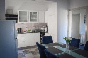 kuchnia ze stołem i niebieskimi krzesłami oraz stołem i kuchnią w obiekcie Kuća za odmor Ante w mieście Ilok