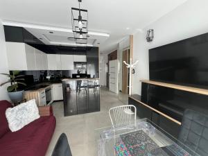 a living room with a red couch and a kitchen at Hortensja 2 Check-in 24H in Oborniki
