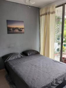 een bed in een slaapkamer met een groot raam bij Apto 3 alcobas, Segundo piso Norte de Cali in Cali