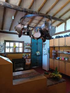 eine Küche mit einem Haufen Töpfe und Pfannen, die an der Decke hängen in der Unterkunft Casa rústica com piscina - SJC in Eugênio de Melo