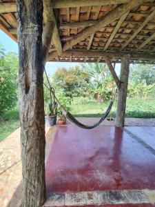 eine Veranda mit einer Hängematte, die von einem Baum hängt in der Unterkunft Casa rústica com piscina - SJC in Eugênio de Melo
