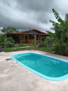 een groot blauw zwembad voor een huis bij Casa rústica com piscina - SJC in Eugênio de Melo