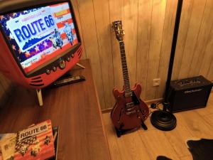 a guitar sitting next to a tv with a video game at Ranch 66 - Zlatokopecká chata Arizona in Tršice