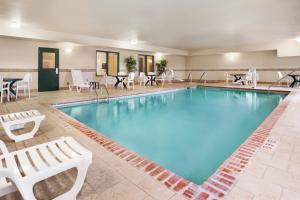 una piscina con sillas y mesas en una habitación de hotel en Country Inn & Suites by Radisson, Northwood, IA, en Northwood