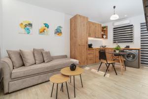 een woonkamer met een bank en tafels en een keuken bij Urban Chic Apartment in the Heart of Athens in Athene
