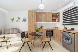 een keuken en een woonkamer met een tafel en stoelen bij Urban Chic Apartment in the Heart of Athens in Athene