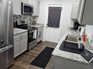 cocina con armarios blancos y fogones en Tranquil Retreat: Short-Term Luxury Rental en Atlanta