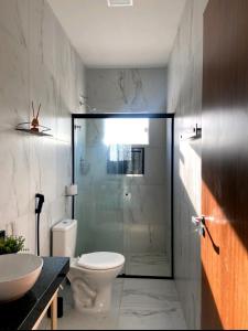 a bathroom with a shower and a toilet and a sink at Beach House Praia de Carapibus in Jacumã