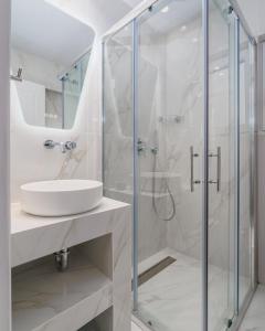 een witte badkamer met een wastafel en een douche bij Urban Chic Apartment in the Heart of Athens in Athene