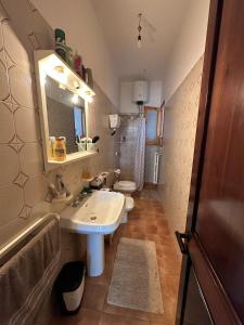a bathroom with a sink and a toilet and a mirror at Poesia del Salento in Roca Vecchia