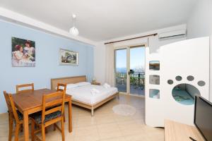 Una sala de estar con una mesa de comedor y una cama. en Lorel's Homes, en Vlorë