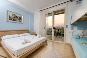 Un dormitorio con una cama grande y un balcón. en Lorel's Homes, en Vlorë