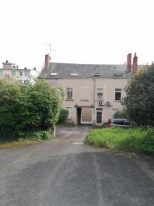 a large white building with a garage next to a street at Appartement-Vierzon-centre in Vierzon