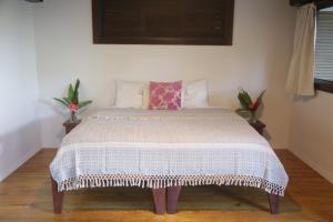 a bedroom with a bed with a white comforter at Roam Yoga & Wellness Lodge in Bocas del Toro