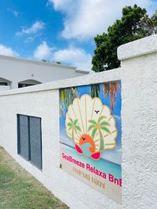 a banner on a white wall with a sign on it at SeaBreeze Relaxa BnB in Hibberdene