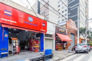 un coche aparcado frente a una tienda en una calle de la ciudad en Sossegado Studio no Brás com Piscina/Metrô Brás, en São Paulo