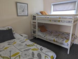 a bedroom with two bunk beds and a window at Hemsby Holiday Home - Norfolk beach & seaside fun in Great Yarmouth