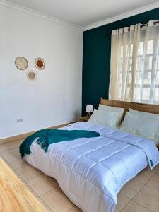 sypialnia z dużym łóżkiem z niebieskimi ścianami w obiekcie Meru Villas w mieście Arusza