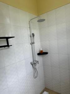 um chuveiro com uma mangueira na casa de banho em Meru Villas em Arusha