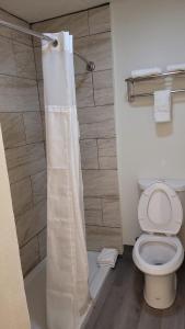 ein Bad mit einem WC und einem Duschvorhang in der Unterkunft Econo Lodge Las Vegas in Las Vegas