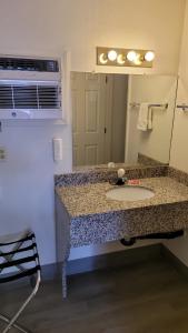 ein Bad mit einem Waschbecken und einem Spiegel in der Unterkunft Econo Lodge Las Vegas in Las Vegas
