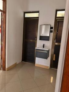 a bathroom with a sink and a door at Meru Villas in Arusha