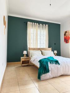 1 dormitorio con 1 cama grande y pared azul en Meru Villas, en Arusha
