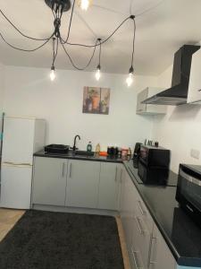 a kitchen with white cabinets and a black counter top at 1 Bed Apartment Oxford - Fits 4 Guests in Oxford