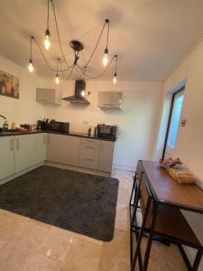 a kitchen with white cabinets and a table at 1 Bed Apartment Oxford - Fits 4 Guests in Oxford
