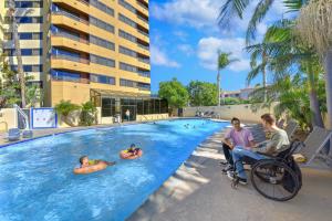 people in wheelchairs in a swimming pool at a hotel at Embassy Suites by Hilton Anaheim-Orange in Anaheim