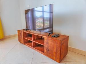 a wooden dresser with a mirror on top of it at Summer in Garuga in Entebbe