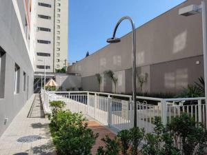 una luz de la calle en una acera junto a un edificio en Lindo Studio no Brás com Piscina/Metrô Brás, en São Paulo