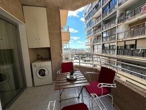 a balcony with a table and chairs and a washing machine at Santa Pola port, sea view in Santa Pola