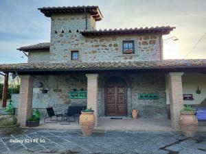 a stone house with a wooden door and a patio at Casale I Pioppi in Vitorchiano