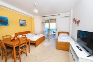 Sala de estar con 2 camas y mesa de comedor en Lorel's Homes, en Vlorë