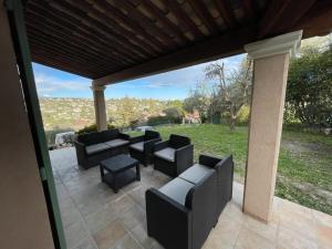 a patio with black furniture and a view of a park at VILLA BIOT in Biot