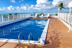 una piscina en un balcón con el océano en el fondo en Apt à Beira-Mar Cabo Branco c ótima área de lazer, en João Pessoa