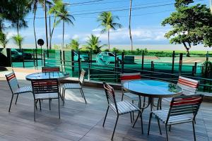 un patio con mesas y sillas y vistas al océano en Apt à Beira-Mar Cabo Branco c ótima área de lazer, en João Pessoa