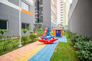 a childrens playground with a play set in a garden at Maravilhoso Studio no Brás com Piscina/Metrô Brás in São Paulo