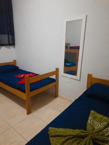 a bedroom with two beds and a mirror at Casa Maria Vitória in Aparecida