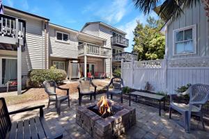 a patio with chairs and a fire pit in front of a house at HG Coastal in Demere Park